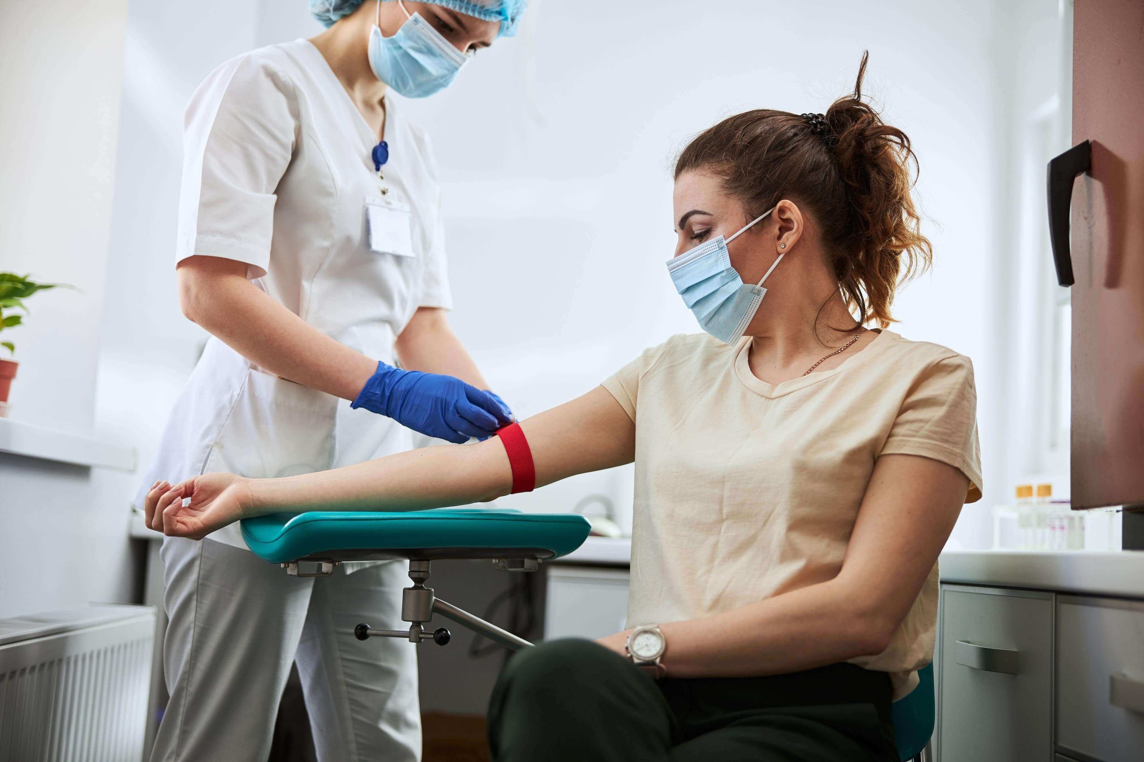 Medical personnel taking blood from patient